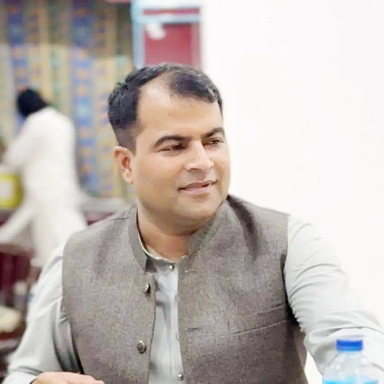 Hakeem Shahzad Dawakhana founder in traditional attire during a meeting.